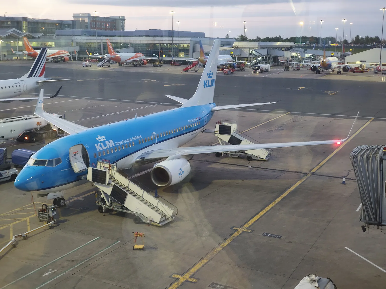 A blue KLM plane waiting at the airport gate, ready for an adventure.