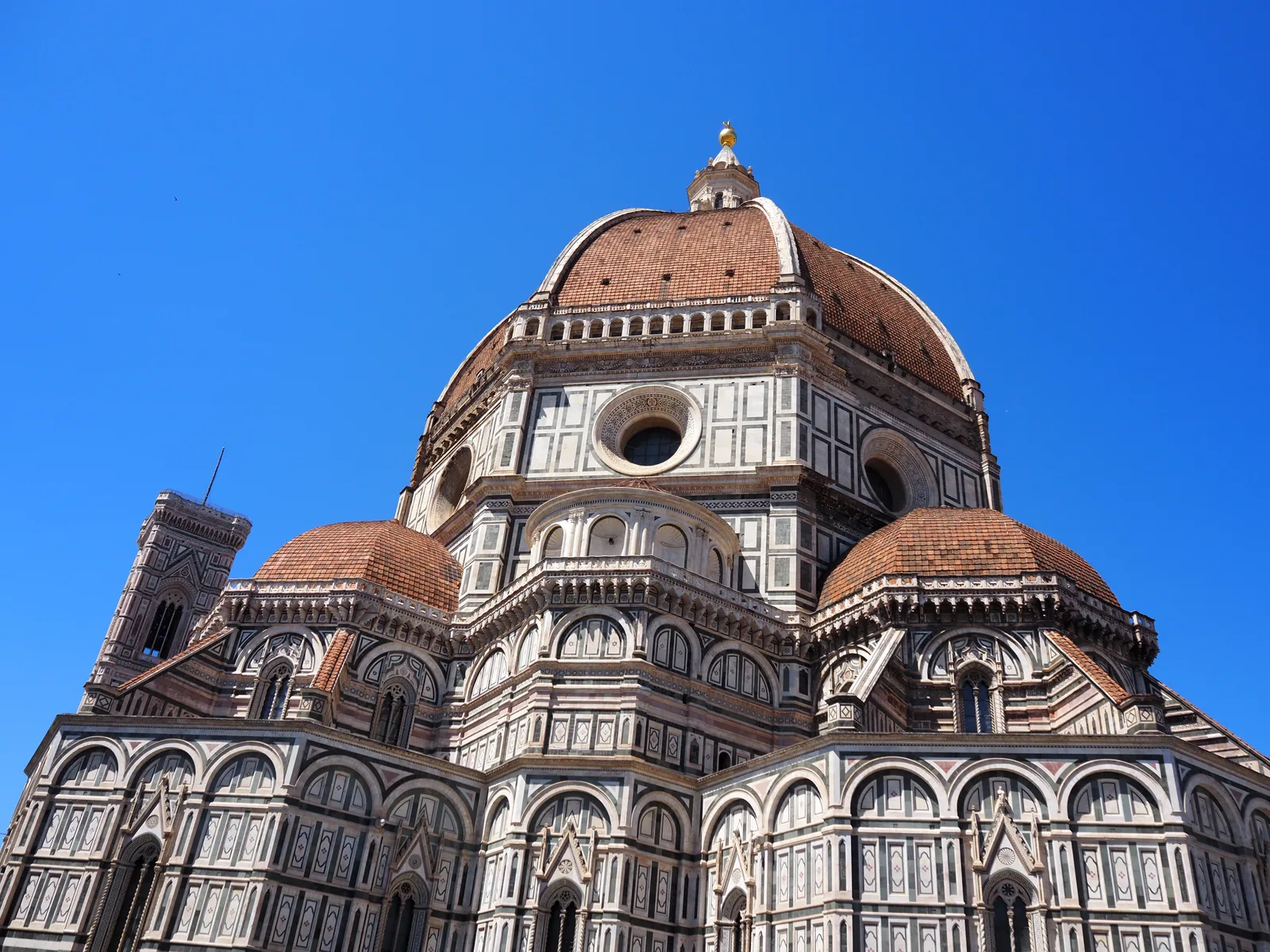 The tiled dome and patterned marble of Florence’s cathedral against a bright blue sky.